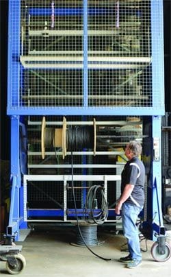 Stafford pauses to look at a vertical carousel in the SJF machine shop.